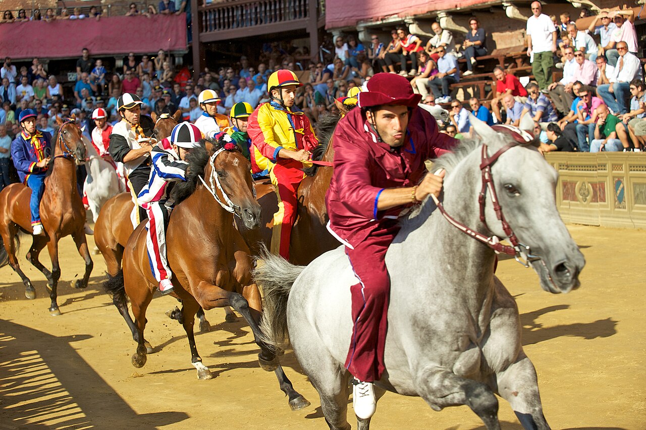 “Historic Palio di Siena horse race in Italy with participants representing different neighborhoods.”